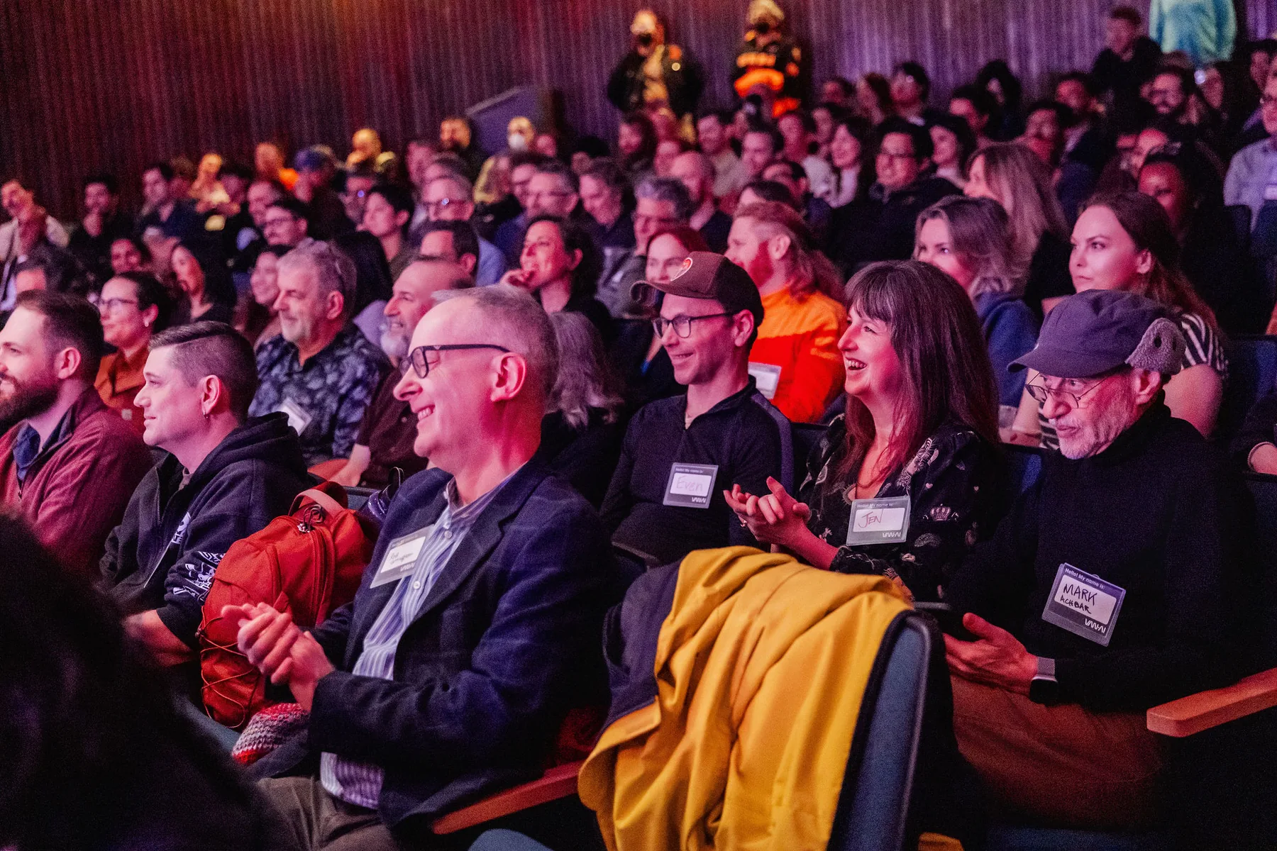 Packed Space Centre audience smiling under warm event lighting